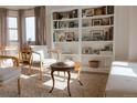 Cozy living area featuring a bookcase, sitting chairs, accent table, and neutral decor at 6512 S Taft Way, Littleton, CO 80127