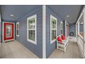 Charming covered porch with seating, a red door, and natural light at 6526 N Windfield Ave, Parker, CO 80134