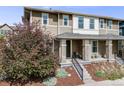 View of a charming home featuring a covered front porch, stylish exterior paint, and mature landscaping at 2820 Macon Way, Denver, CO 80238