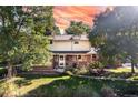 Attractive two-story brick home with a well-kept lawn and mature trees at 6906 S Sycamore St, Littleton, CO 80120