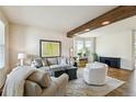 Bright living room features stylish furniture, a cozy area rug, a decorative beam, and lots of natural light at 1997 Fox Haven Dr, Castle Rock, CO 80104