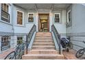 Apartment building entryway with staircase, wrought iron railings, and brick accents, inviting and secure at 215 E 11Th Ave # B9, Denver, CO 80203