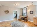 Living room featuring neutral walls, hardwood floors, and a decorative rug under a wooden table set with chairs at 215 E 11Th Ave # B9, Denver, CO 80203