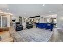 Open living room with light-toned wood floors, comfortable seating, and a decorative rug at 4790 E Dartmouth Ave, Denver, CO 80222