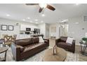 Inviting open-concept living space with leather furniture, stylish decor, and a seamless flow to the kitchen at 2328 Saddle Back Ct, Fort Lupton, CO 80621