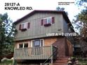 Exterior view of a two-story home with wood siding, brick accents, and a small porch at 28127 Knowles Rd # Ab&C, Evergreen, CO 80439