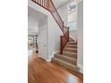 A staircase featuring carpeted steps, a wooden handrail, and a large window providing natural light at 2521 N Xenia St, Denver, CO 80238