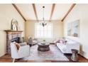 Bright living room with hardwood floors, fireplace, wood beams, and ample seating at 9867 W Berry Dr, Littleton, CO 80123