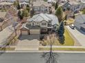 Overhead view of a two-story home featuring a three-car garage, well-manicured lawn, and mature landscaping at 15844 E Lake Cir, Centennial, CO 80016