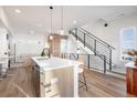 Open floor plan features kitchen island with seating, perfect for entertaining, next to stairway at 2900 W Parkside Pl, Denver, CO 80221