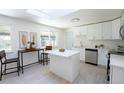 Updated kitchen boasting stainless steel appliances, white cabinets, an island and skylight, offering a modern design at 5041 S Julian St, Englewood, CO 80110