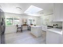 Bright kitchen features white cabinetry, stainless appliances, a skylight, and a center island perfect for entertaining at 5041 S Julian St, Englewood, CO 80110