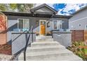 Inviting front porch with stylish lighting and a natural wood door at 1538 Albion St, Denver, CO 80220