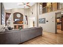 Inviting living room with vaulted ceiling, large windows, a fireplace, and an oversized gray sectional sofa at 6190 Sparrow Ave, Firestone, CO 80504