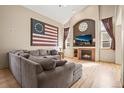 Comfortable living room featuring vaulted ceilings, large windows, and a cozy fireplace at 6190 Sparrow Ave, Firestone, CO 80504