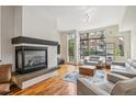 Bright living room features a cozy fireplace, hardwood floors, and large windows with neighborhood views at 2325 Walnut St # 4, Denver, CO 80205