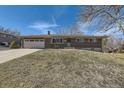 Charming brick home featuring an attached garage and a well-maintained lawn at 1701 S Valentine Way, Lakewood, CO 80228