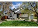 Charming home with a well-maintained lawn, landscaping, and an American flag at 879 E 133Rd Ave, Thornton, CO 80241