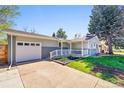 Attractive single-story home with a white garage door, a front porch, and a well-manicured lawn at 860 Waite Dr, Boulder, CO 80303