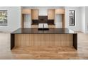 A kitchen island with dark countertops and light wood cabinets at 4303 Osceola St, Denver, CO 80212