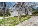 Inviting gray two-story home with a manicured lawn, stone walkway, and delightful landscaping at 5934 S Yampa St, Aurora, CO 80016