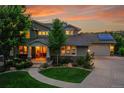 Charming home featuring a covered porch, well-manicured lawn, mature trees, and solar panels above the garage at 24965 E Roxbury Pl, Aurora, CO 80016