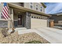 Close-up of a home's exterior showing the stone-accented facade, a two-car garage, and an inviting front entry at 25621 E Cedar Pl, Aurora, CO 80018