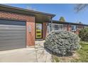 Brick home featuring attached garage and stylish yellow front door at 5485 E Bails Dr, Denver, CO 80222