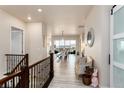 Bright hallway featuring hardwood floors, staircase and an open layout leading into the dining area at 6657 S Kline Way, Littleton, CO 80127