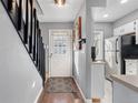 Welcoming entryway with a staircase, leading to the kitchen with modern white appliances at 8140 S Fillmore Cir, Centennial, CO 80122