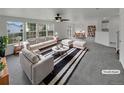 Bright living room with large windows, stylish furniture, and a ceiling fan at 16453 E Phillips Dr, Englewood, CO 80112