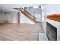 Spacious living room featuring light hardwood floors, fireplace, and a staircase at 8034 Decatur St, Westminster, CO 80031