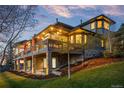 Stylish two-story home featuring a stone facade, lighted deck, and lush landscaping at 5602 Silver Bluff Ct, Parker, CO 80134