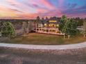 Beautifully landscaped home exterior at sunset, with a winding sidewalk and a covered deck at 5602 Silver Bluff Ct, Parker, CO 80134