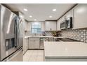 Modern kitchen featuring stainless steel appliances, updated cabinets, backsplash, and quartz countertops at 12685 E Pacific Cir # B, Aurora, CO 80014
