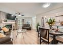 Bright living room with a fireplace, modern decor, dining area, and open access to the kitchen at 12685 E Pacific Cir # B, Aurora, CO 80014