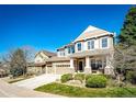 Attractive two-story house with stone accents, a spacious driveway, and manicured green lawn at 4307 Lilly Gulch Trl, Castle Rock, CO 80109