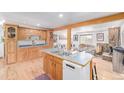 Open kitchen featuring wood cabinets, a center island with a sink, and hardwood floors at 5070 W 66Th Ave, Arvada, CO 80003