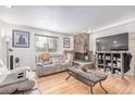 Comfortable living room with a stone fireplace, hardwood floors, and modern furnishings at 5070 W 66Th Ave, Arvada, CO 80003