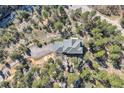 Areal view of a secluded mountain home surrounded by mature trees, a driveway, and rock outcroppings at 9659 S Turkey Creek Rd, Morrison, CO 80465