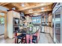 Gourmet kitchen featuring custom wood cabinetry, a large center island with stools, and stainless steel appliances at 9659 S Turkey Creek Rd, Morrison, CO 80465