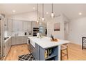 Modern kitchen with stainless appliances, large center island with barstool seating, and open design at 4711 S Logan St, Englewood, CO 80113