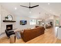 Cozy living room with a stone fireplace, hardwood floors, and an open layout to the kitchen at 4711 S Logan St, Englewood, CO 80113