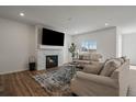 Comfortable living room with a fireplace, mounted TV, plush sofas, stylish rug, and plenty of natural light at 18001 Herrera Dr, Parker, CO 80134