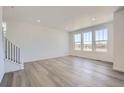 Bright living room with hardwood floors, fresh white walls, and large windows at 5581 Inland Ave, Firestone, CO 80504