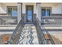 Inviting covered front porch with decorative columns and a well-lit entrance at 10723 Sedalia St, Commerce City, CO 80022