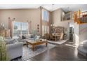 Spacious living room with tall windows, hardwood floors, and elegant dining area at 13087 Krameria St, Thornton, CO 80602