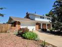 Beautiful two-story home featuring a brick exterior, attached garage, and meticulously landscaped front yard at 984 S Braun Dr, Lakewood, CO 80228