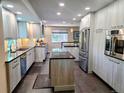 Modern kitchen featuring sleek cabinetry, stainless steel appliances, and a center island with stone countertops at 984 S Braun Dr, Lakewood, CO 80228
