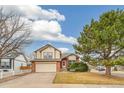 Charming two-story home with a two-car garage, brick accents, and a well-maintained front yard and mature trees at 10663 Dexter Dr, Thornton, CO 80233